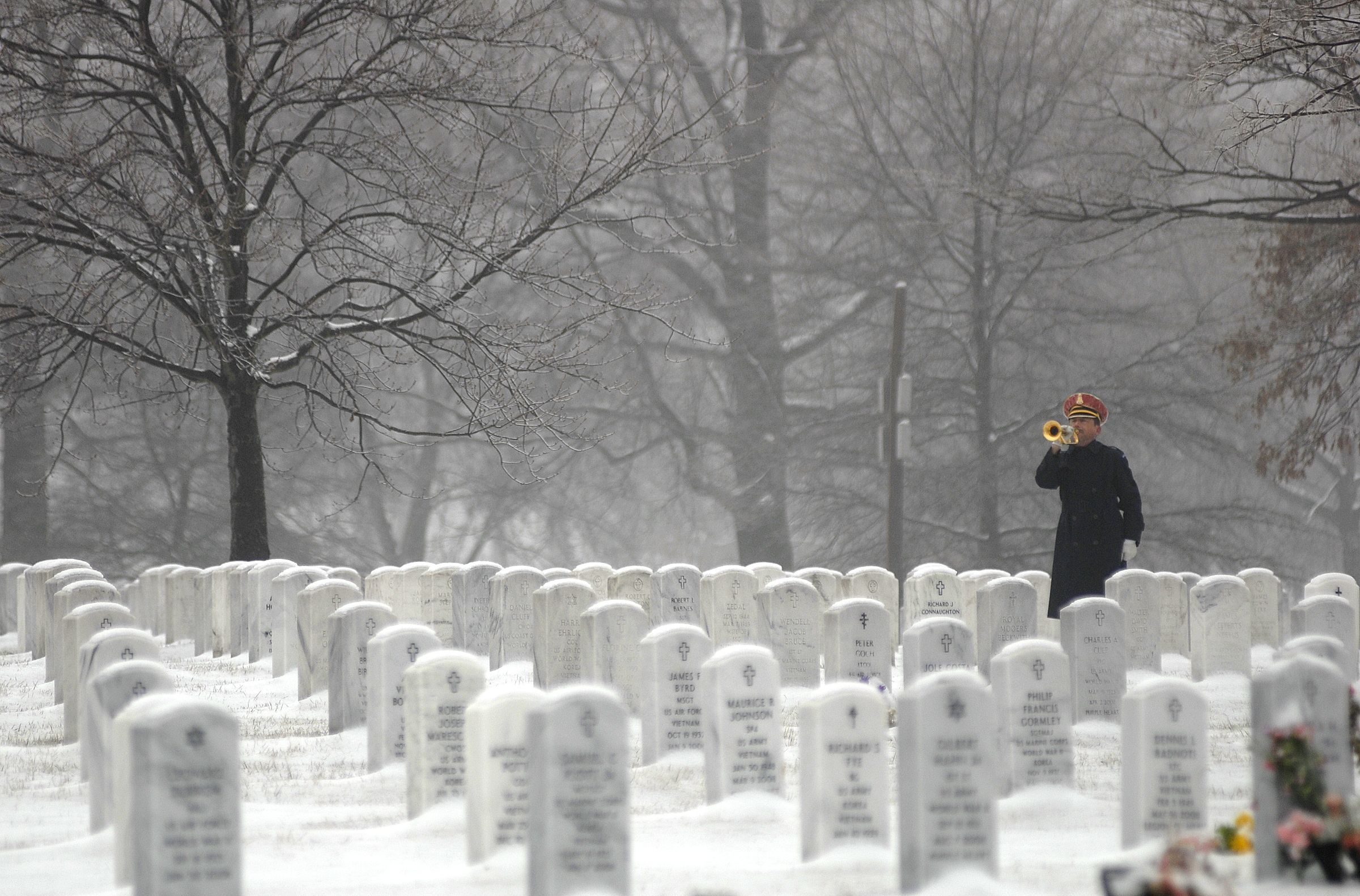 Taps is played on the bugle in the winter snow at Arlington National Cemetery